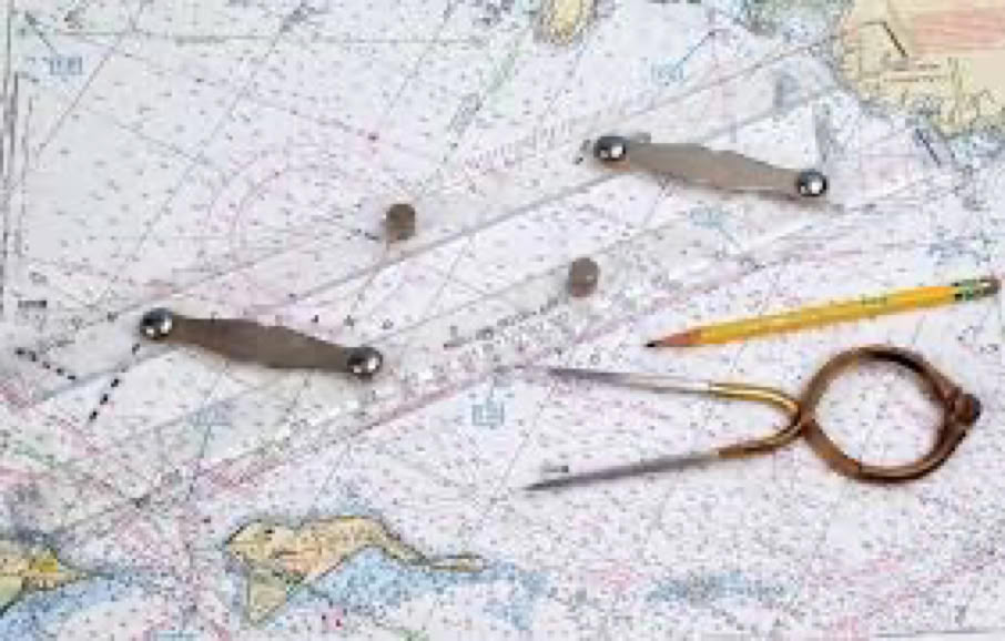 A nautical chart with a parallel ruler, a pencil, and a pair of dividers placed on top.