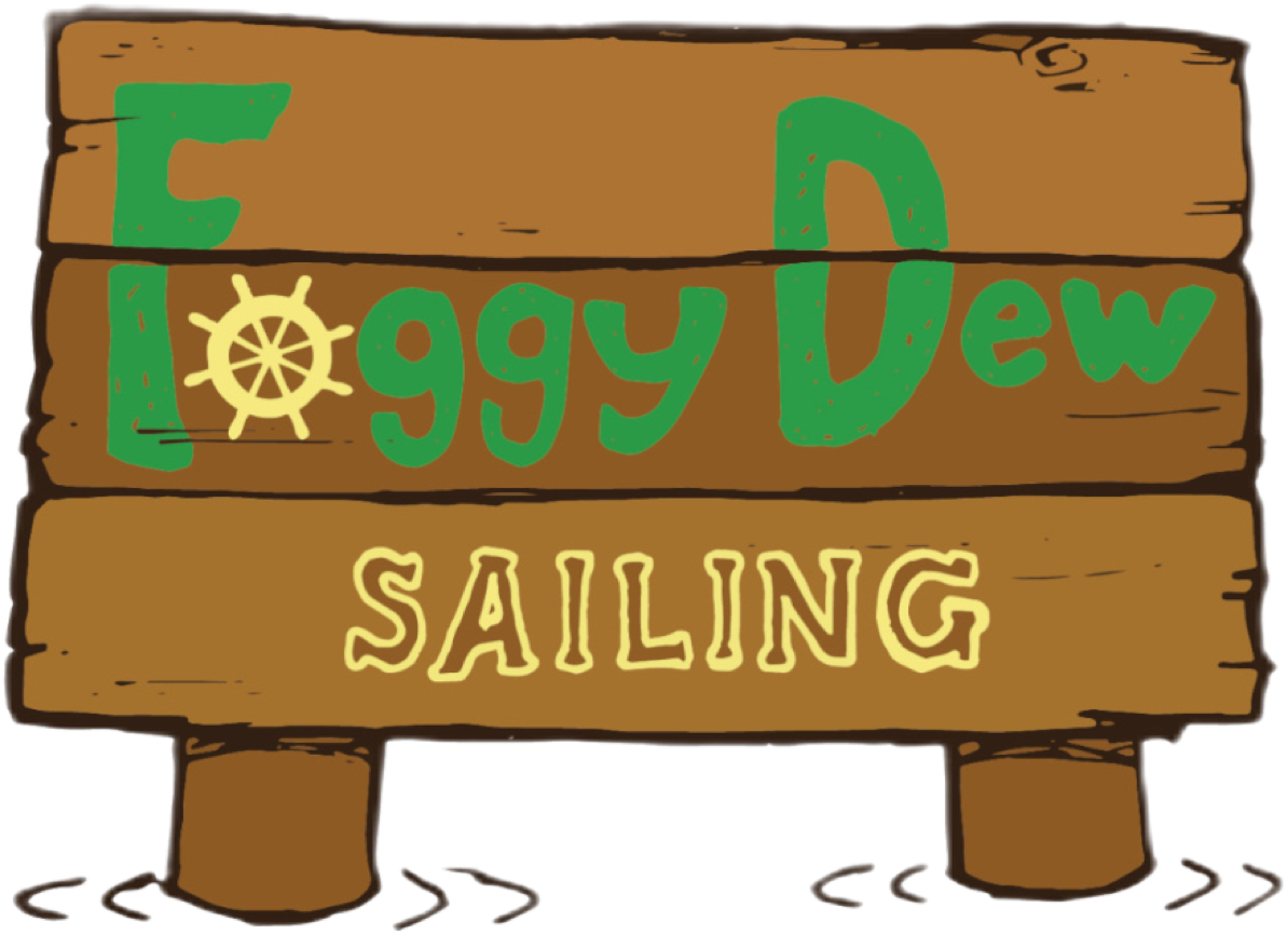 A wooden sign with the text "Foggy Dew Sailing" in green and yellow letters, featuring a ship's wheel as the letter "o" in "Foggy."