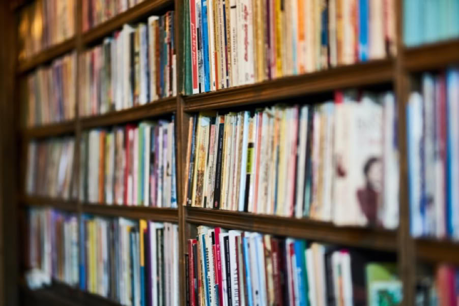 A bookshelf filled with various books in a library or study setting.